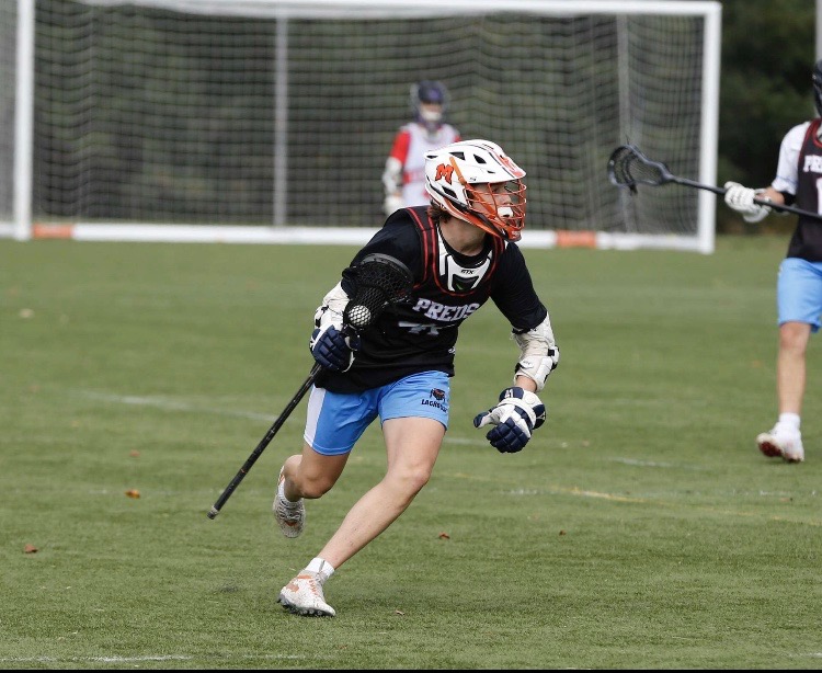 Alex Martin bolts down the field in a lacrosse game.