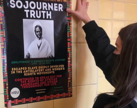 Emilia Pantigoso (‘21) hangs a poster honoring Sojourner Truth in the overpass.