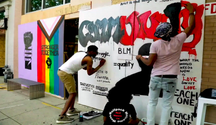 A shot of Black Lives Matter activists painting from the MLK Day virtual assembly video.