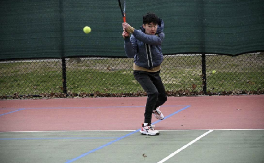 Junior Max Li, a singles player on Boys Varsity Tennis, returns a shot at Flint Park.
