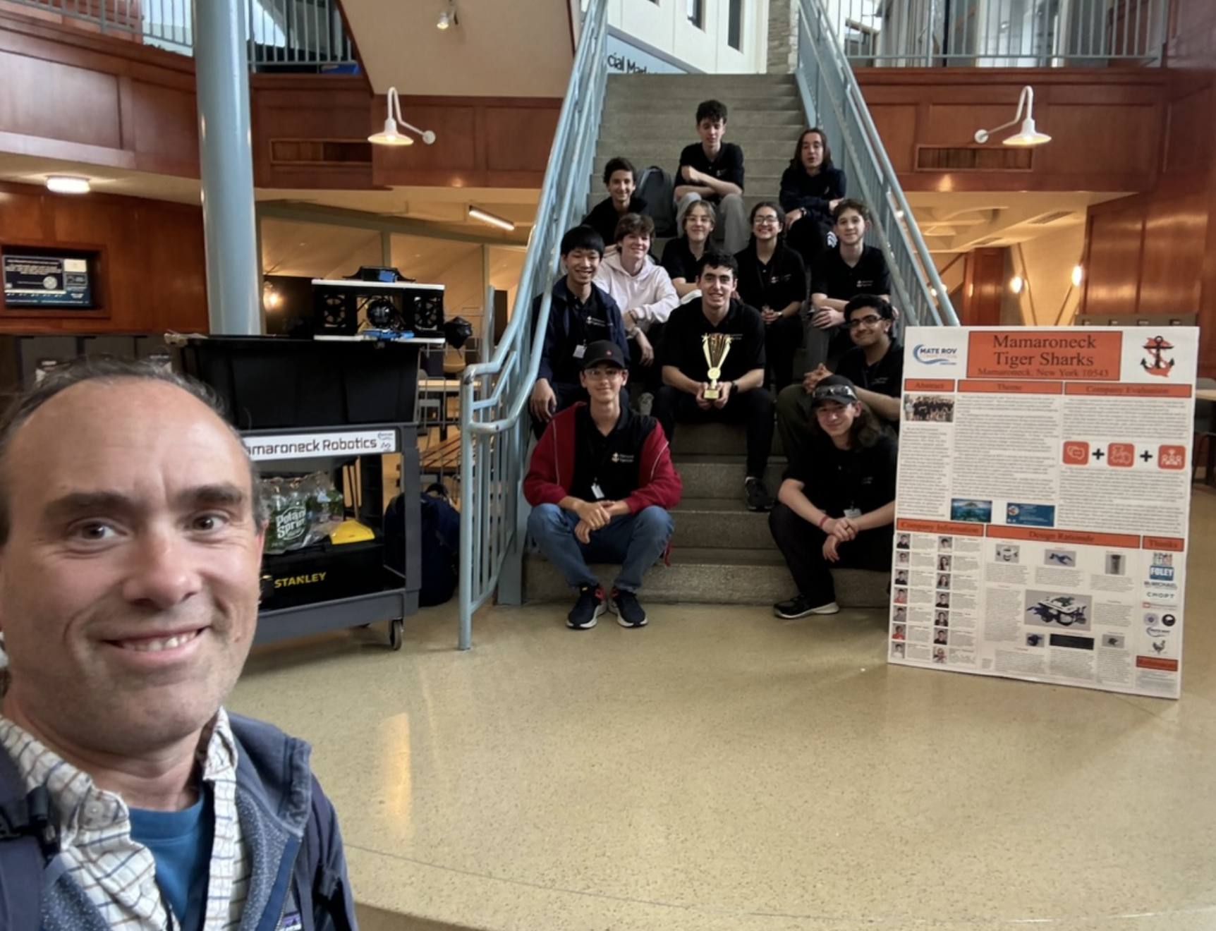 The Mamaroneck Tiger Sharks pose with their award and their team marketing display.