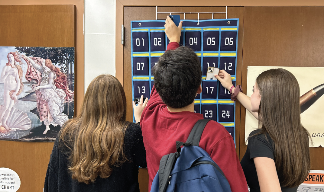 Students placing their phones in the newly implemented ‘phone caddy.’