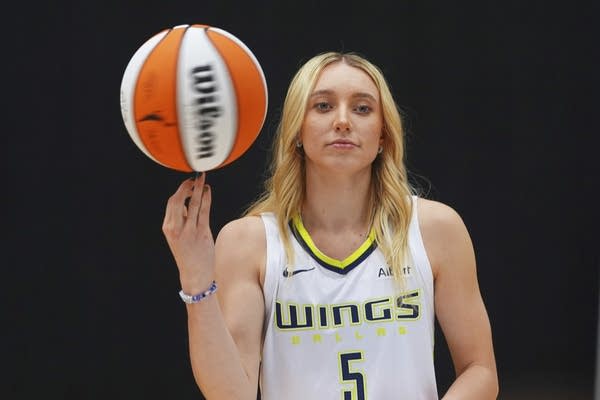Paige Bueckers effortlessly spins a basketball on her finger.
