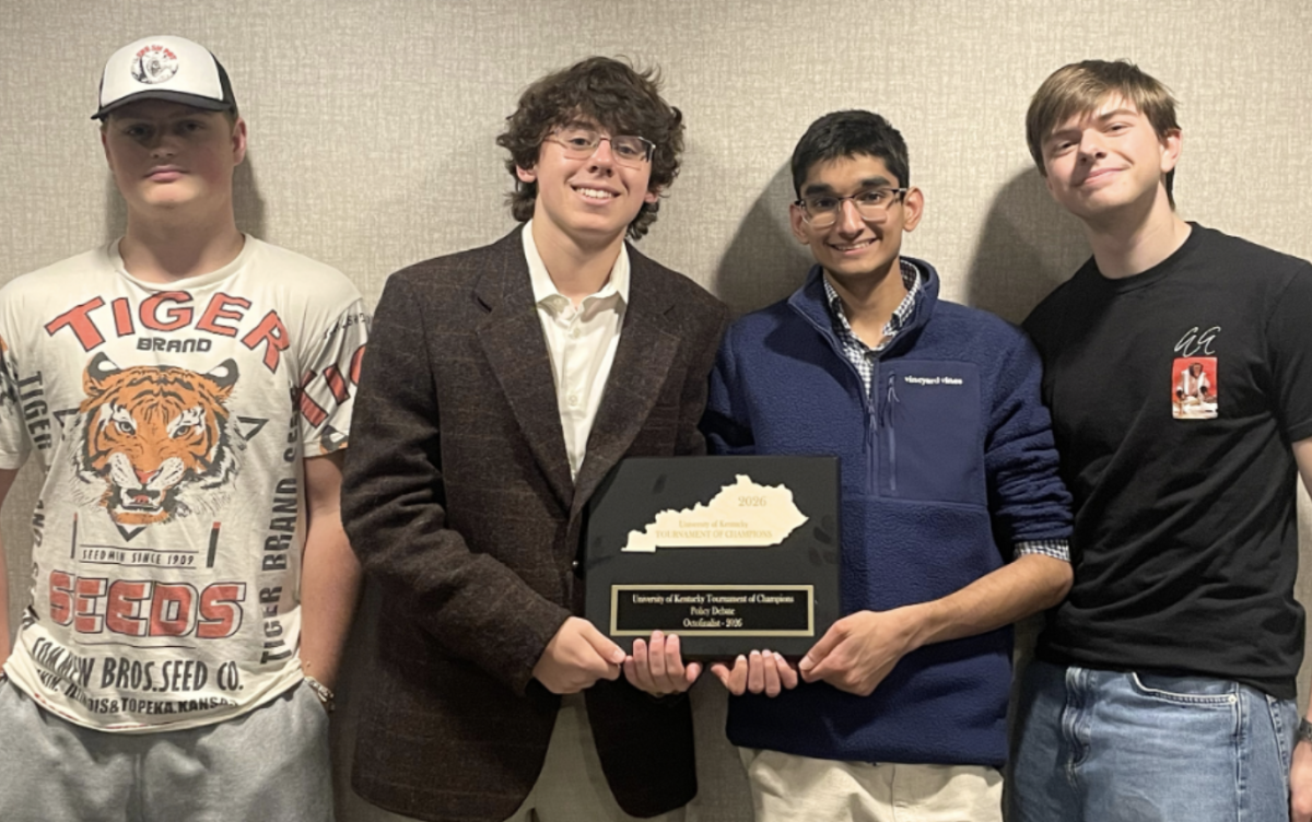 Members of the Debate Team pose with their Tournament of Champions Plaque